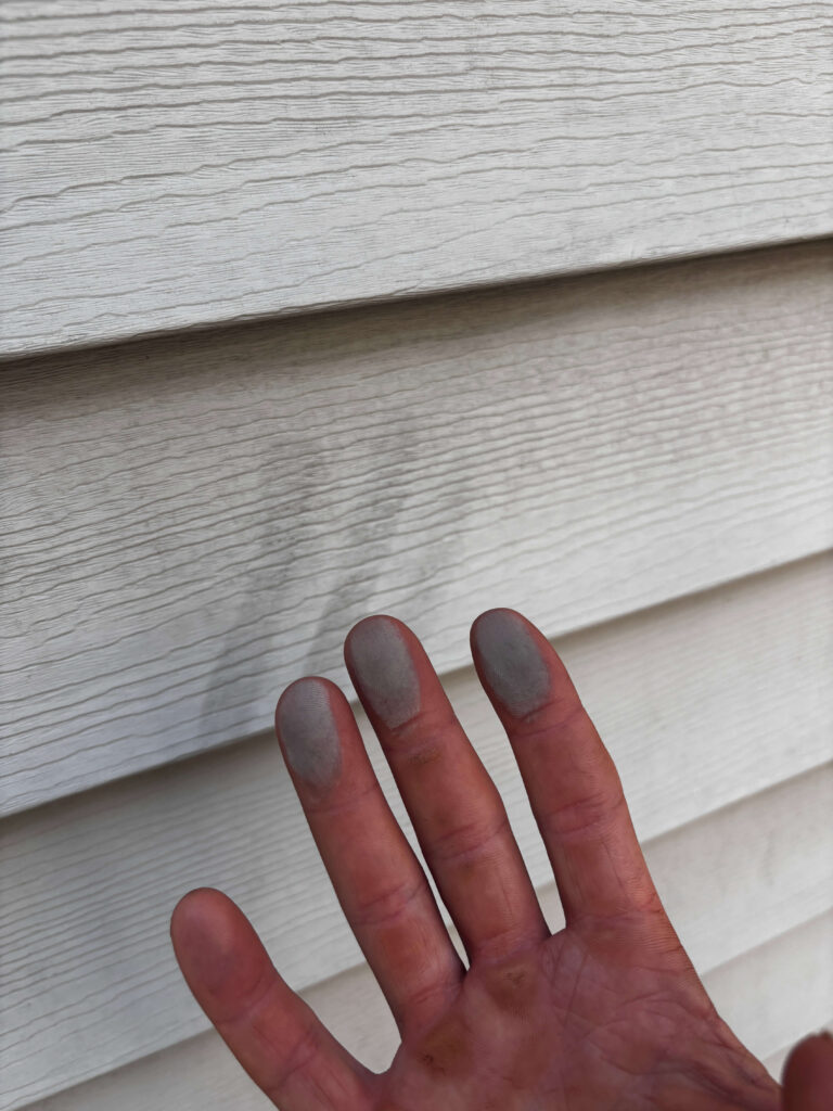 Chalky vinyl siding oxidation residue on hand before oxidation removal in Roanoke, VA.